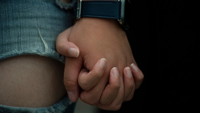 Two people hold hands. (File Photo by Miguel Candela/SOPA Images/LightRocket via Getty Images)