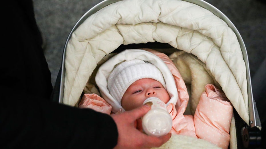 A refugee baby is given bottle-feeding after arriving from Ukraine at the main railway station in Krakow, Poland on March 11, 2022. Russian invasion on Ukraine causes a mass exodus of refugees to Poland. (Photo by Beata Zawrzel/NurPhoto via Getty Images)