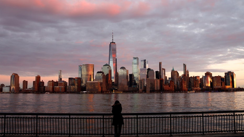 JERSEY CITY, NJ - JANUARY 1: The sun sets in the skyline if lower Manhattan and One World Trade Center in New York City on January 1, 2023, as seen from Jersey City, New Jersey. (Photo by Gary Hershorn/Getty Images)