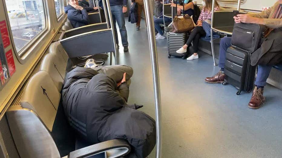 A person sleeps on the AirTrain at JFK Airport.