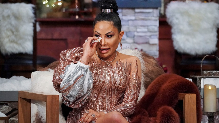 Real Housewives star Jenn Shah wipes tears during a televised reunion show with the cast.