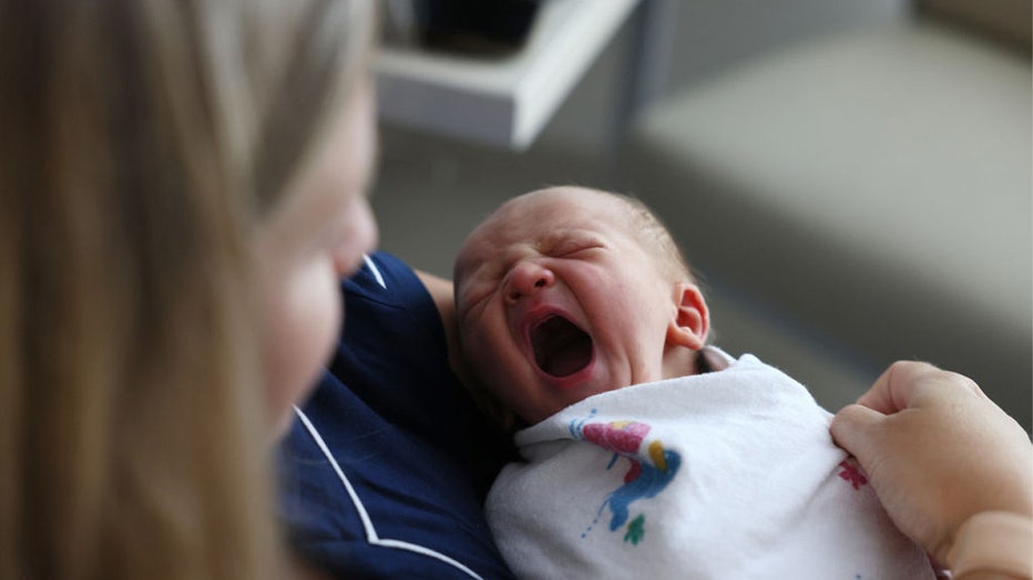 Concord, MA - July 28: A newborn baby boy yawns as he sits with his mother at Emerson Hospital. Births rebounded to pre-pandemic levels in Massachusetts, rising 4 percent in 2021 after plummeting by the same margin in 2020, according to new data from the National Center for Health Statistics. (Photo by Jessica Rinaldi/The Boston Globe via Getty Images)