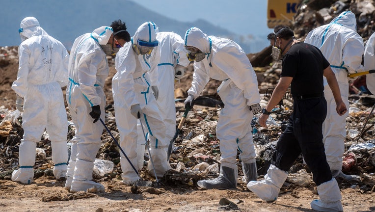 Police officers dress in PPEs searching a part of the Landfill for Evidence in a murder case on February 28, 2023 in Hong Kong, China. Over 100 police officers search for the missing torso and arms of murdered and dismembered Hong Kong socialite and model Abby Choi Tin-fung in a Landfill in the New Territories. (Photo by Vernon Yuen/NurPhoto via Getty Images)