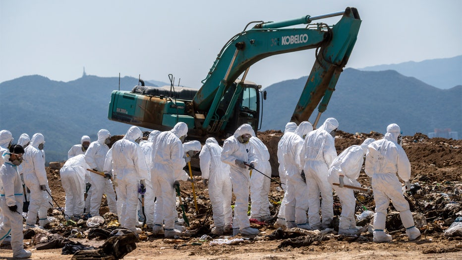 Police officers dress in PPEs searching a part of the Landfill for Evidence in a murder case on February 28, 2023 in Hong Kong, China. Over 100 police officers search for the missing torso and arms of murdered and dismembered Hong Kong socialite and model Abby Choi Tin-fung in a Landfill in the New Territories. (Photo by Vernon Yuen/NurPhoto via Getty Images)