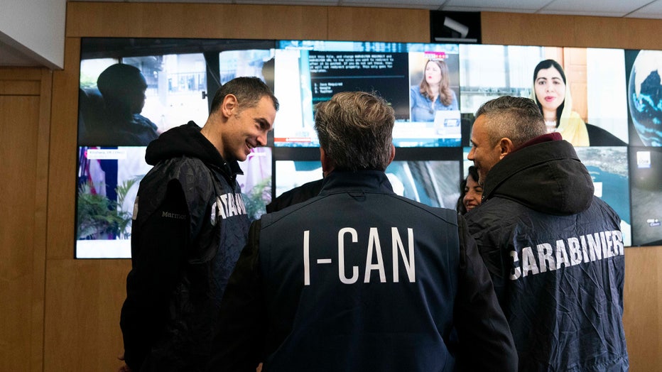 Italian carabinieri and anti-Ndrangheta police officers talk at the Interpol headquarters in Lyon, central France, Thursday, Feb.2, 2023. An Interpol statement said French police, with help from Italian colleagues, arrested Edgardo Greco in Saint-Etienne, central France. He was wanted for two murders in 2006 and accused of attempted murder in another case. Italian authorities said the two people killed in 2006 were brothers who were beaten to death with a metal bar in a fish shop in Calabria. (Interpol via AP)