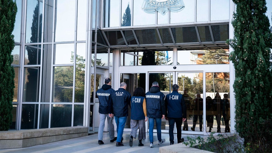 Italian carabinieri and anti-Ndrangheta police officers arrive at the Interpol headquarters in Lyon, central France, Thursday, Feb.2, 2023. An Interpol statement said French police, with help from Italian colleagues, arrested Edgardo Greco in Saint-Etienne, central France. He was wanted for two murders in 2006 and accused of attempted murder in another case. Italian authorities said the two people killed in 2006 were brothers who were beaten to death with a metal bar in a fish shop in Calabria. (Interpol via AP)