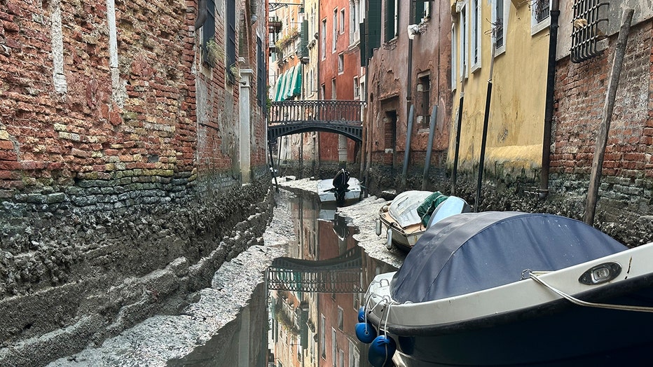 Boats are docked along a canal during a low tide in Venice, Italy, Monday, Feb. 20, 2023. Some ofVenice's secondary canals have practically dried up lately due a prolonged spell of low tides linked to a lingering high-pressure weather system. (AP Photo/Luigi Costantini)