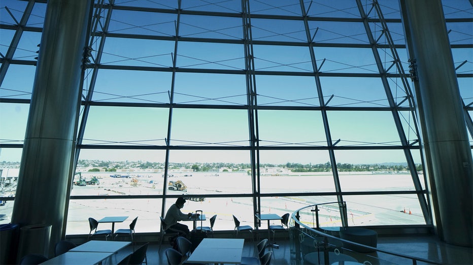 SAN DIEGO, CA-MAY20: A lone traveller waits to board his flight at San Diego International Airport on May 20, 2020 in San Diego, California. Air travel is down as estimated 94 percent due to the coronavirus (COVID-19) pandemic, causing U.S. airlines to take a major financial hit with losses of $350 million to $400 million a day as nearly half of major carriers' planes sit idle. (Photo by Sandy Huffaker/Getty Images)
