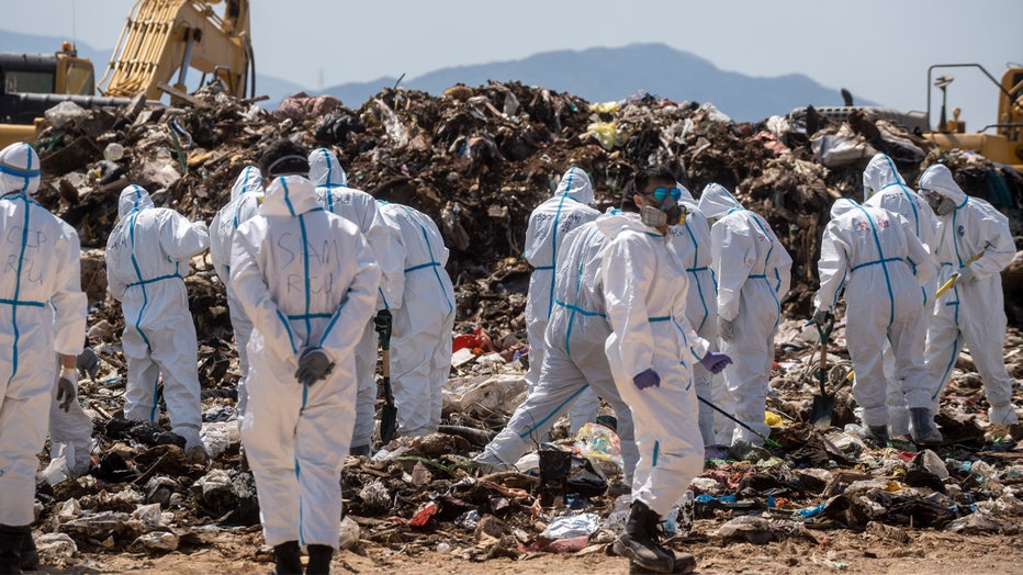 Police officers dress in PPEs searching a part of the Landfill for Evidence in a murder case on February 28, 2023 in Hong Kong, China. Over 100 police officers search for the missing torso and arms of murdered and dismembered Hong Kong socialite and model Abby Choi Tin-fung in a Landfill in the New Territories. (Photo by Vernon Yuen/NurPhoto via Getty Images)