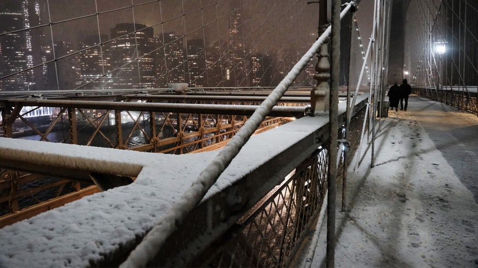 NEW YORK, NEW YORK - FEBRUARY 27: Snow falls as people walk across the Brooklyn Bridge on February 27, 2023 in New York City. Parts of northern New York City could see up to five inches of snow by morning in what would be the first real snowfall of the winter. (Photo by Spencer Platt/Getty Images)