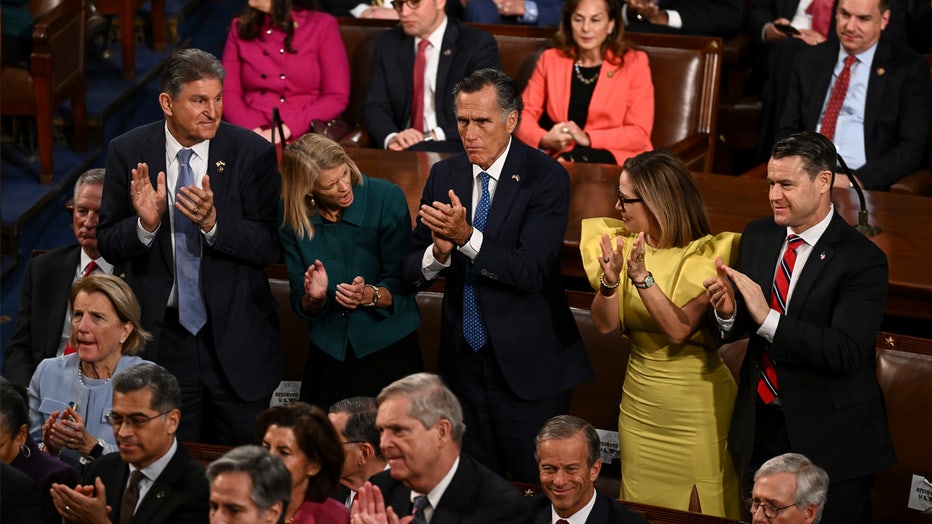 WASHINGTON, DC - FEBRUARY 07: Moderate lawmakers, standing from left to right, Sen. Joe Manchin III (D-W.Va.), Sen. Lisa Murkowski (R-Alaska), Sen. Mitt Romney (R-Utah), Sen. Kyrsten Sinema (D-Ariz.) and Sen. Todd Young (R-Ind.), clap as President Joe Biden delivers his State of the Union address to a joint session of Congress on Capitol Hill on Tuesday, February 7, 2023 in Washington, DC. (Photo by Ricky Carioti/The Washington Post via Getty Images)