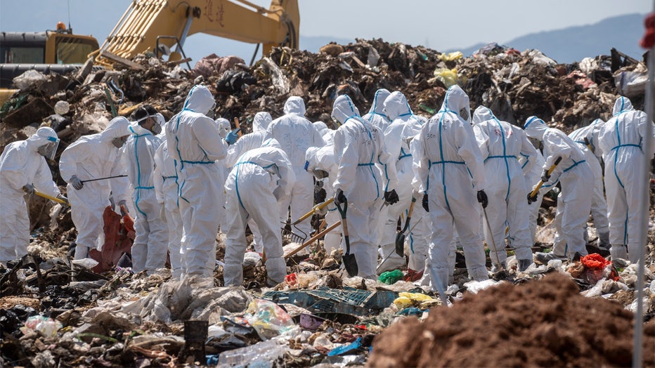 Police officers dress in PPEs searching a part of the Landfill for Evidence in a murder case on February 28, 2023 in Hong Kong, China. Over 100 police officers search for the missing torso and arms of murdered and dismembered Hong Kong socialite and model Abby Choi Tin-fung in a Landfill in the New Territories. (Photo by Vernon Yuen/NurPhoto via Getty Images)