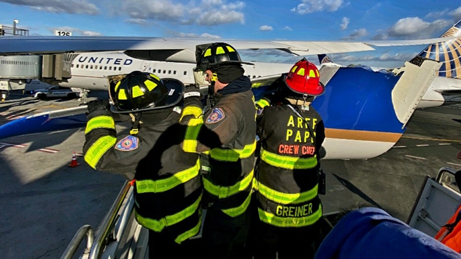 Port Authority Fire Department personnel examine the damaged wing.