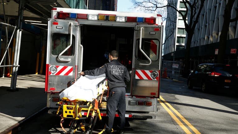 An emergency medical technician prepares a gurney ready to