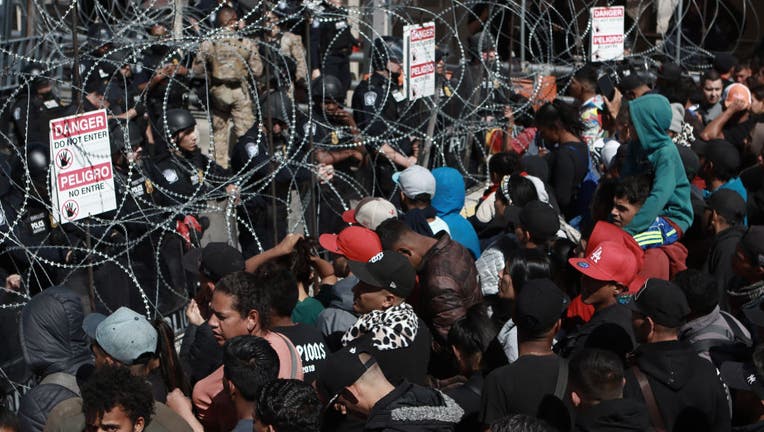 Hundreds of migrants rush the border checkpoint in Mexico