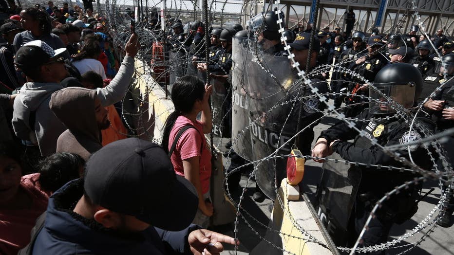 25ea1061-Hundreds of migrants rush the border checkpoint in Mexico