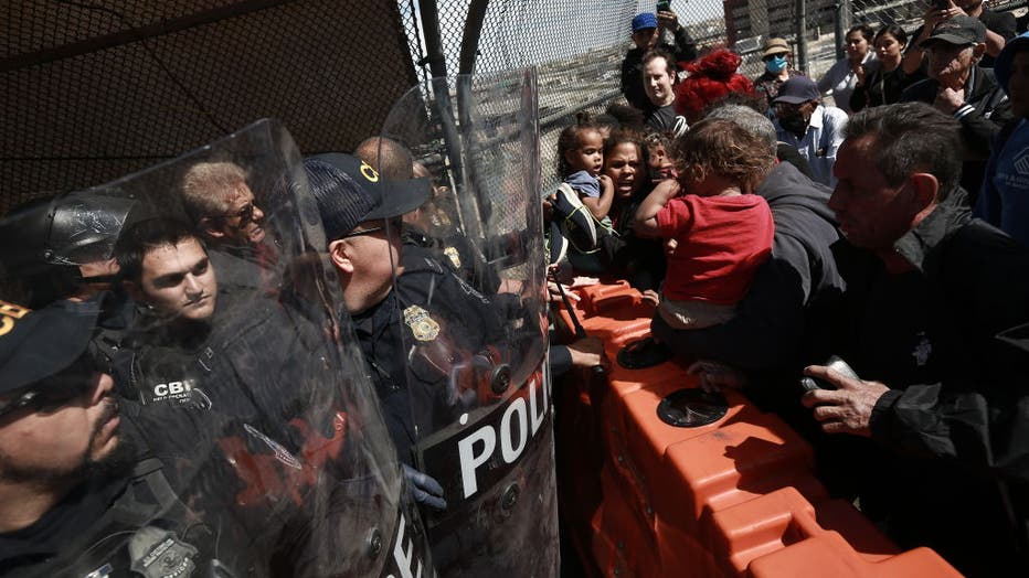 f60d22a3-Hundreds of migrants rush the border checkpoint in Mexico