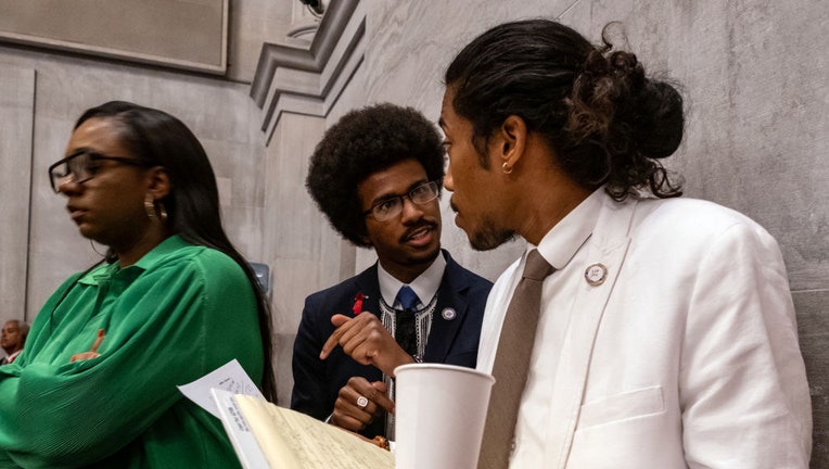 Democratic state Reps. Justin Pearson (C) of Memphis and Justin Jones (R) of Nashville attend the vote in which they were expelled from the state Legislature on April 6, 2023, in Nashville, Tennessee. (Photo by Seth Herald/Getty Images)