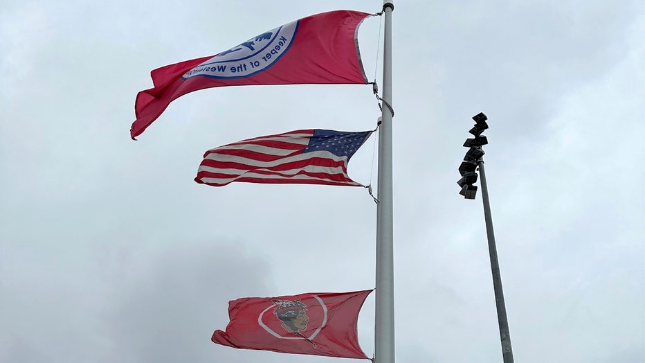 The flags of the Seneca Nation of Indians, Salamanca City Central School District and United States fly over the sports complex in Salamanca, New York, on April 18, 2023. The school district, located on Seneca Nation of Indians territory, may have to replace its logo after New York passed a ban on the use of Indigenous names, mascots and logos by public schools. (AP Photo/Carolyn Thompson)