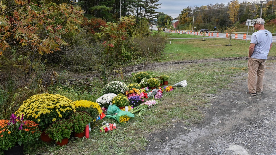 SCHOHARIE, NY - OCTOBER 08: A mourner looks on at the site of the fatal limousine crash on October 8, 2018 in Schoharie, New York. 20 people died in the crash including the driver of the limo, 17 passengers, and two pedestrians. The Limousine's tracks can be seen on the other side of the flowers. (Photo by Stephanie Keith/Getty Images)