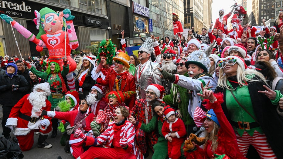 NEW YORK, NEW YORK - DECEMBER 10: People dressed in Santa Claus costumes participate in SantaCon on December 10, 2021 in New York City. SantaCon is an annual Christmas themed pub crawl that raises money for charity. This year, SantaCon created a map and partnered with the app, Wolfie, that display real time updates about the lines, venues, and even friends’ locations. (Photo by Alexi Rosenfeld/Getty Images)