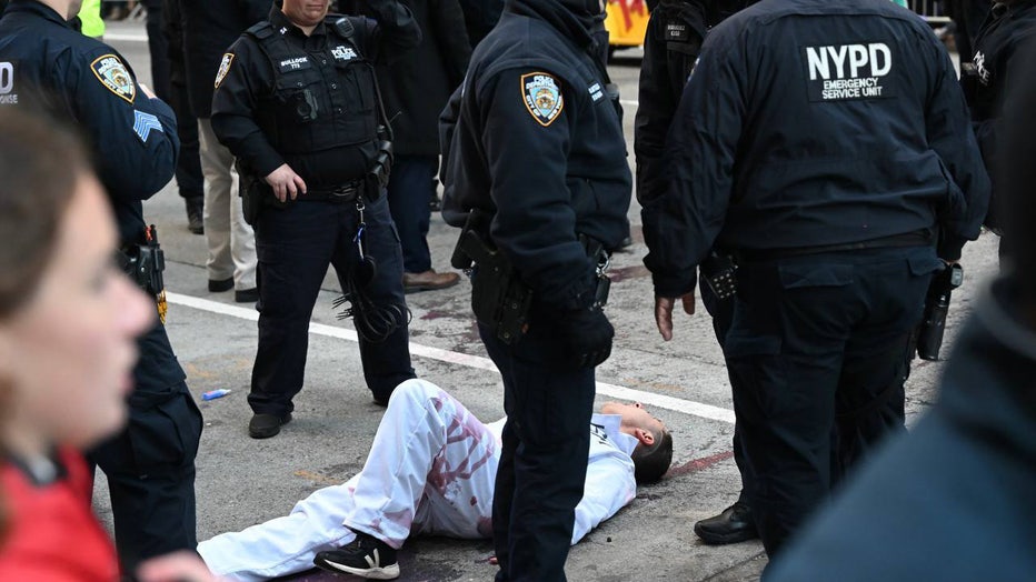 NEW YORK, UNITED STATES - NOVEMBER 23: New York Police Department (NYPD) members intervene and take two pro-Palestinian protesters into custody, who entered the parade, during the traditional Thanksgiving Day parade in New York, United States on November 23, 2023. (Photo by Fatih Aktas/Anadolu via Getty Images)