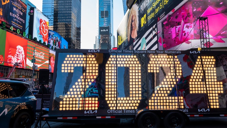 NEW YORK, NEW YORK - DECEMBER 20: People walk by an installation with the 2024 numerals at Times Square on December 20, 2023 in New York City. (Photo by Wang Fan/China News Service/VCG via Getty Images)