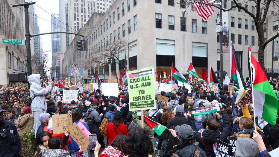 NEW YORK, UNITED STATES - DECEMBER 25: Pro-Palestinian protesters rally in front of the News Corporation building and near the Rockefeller Center Christmas tree, and march on 42nd Street, 5th and Park avenues on Monday, December 25, 2023, in New York City. They chant 'Christmas is canceled' while carrying blood-red mock Nativity scene through New York City streets. The police arrest several protesters and use force while detaining. (Photo by Selcuk Acar/Anadolu via Getty Images)
