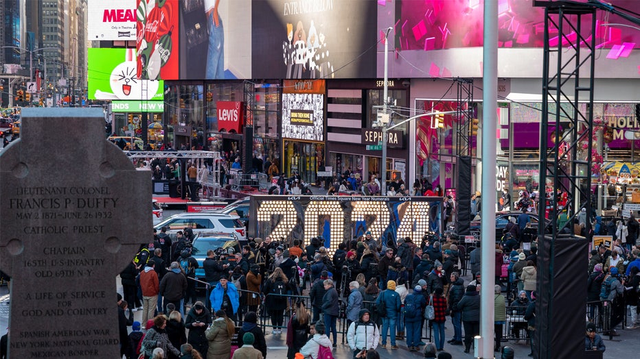 NEW YORK, NEW YORK - DECEMBER 20: People walk by an installation with the 2024 numerals at Times Square on December 20, 2023 in New York City. (Photo by Wang Fan/China News Service/VCG via Getty Images)