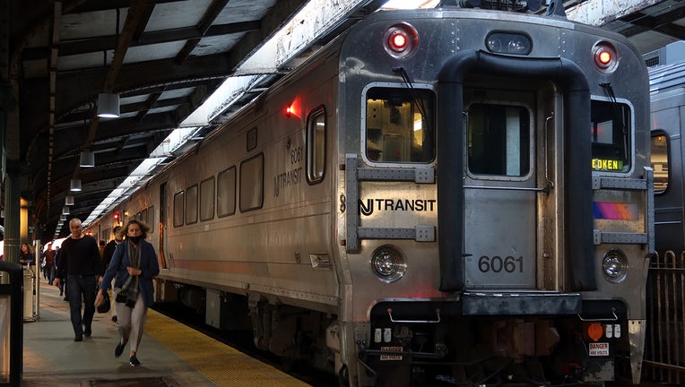 People disembark from a NJ Transit commuter train after arriving at the transit terminal.