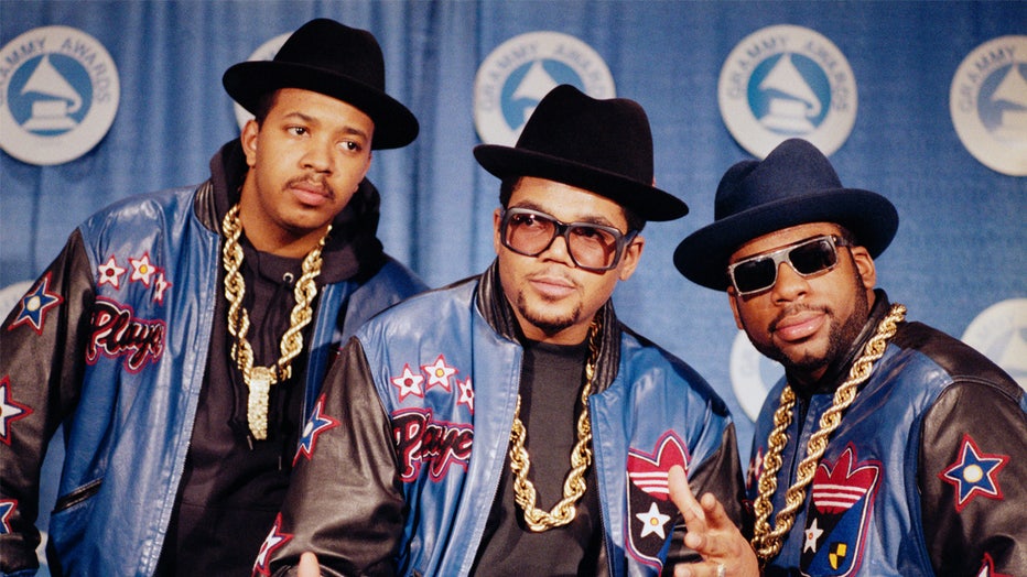 (Original Caption) 3/2/1988- RUN-DMC poses in full regalia that they popularized- heavy gold chains, hats, sunglasses, and Adidas track suits. They have just received the Grammy Awrds. PH: Ezio Petersen
