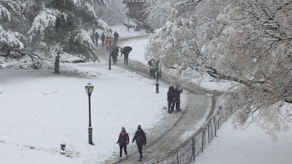 People walk through the snow in Central Park in New York City on February 13, 2024. Heavy snowfall is expected over parts of the Northeast US starting late February 12, with some areas getting up to two inches (5cms) of snow an hour, the National Weather Service forecasters said. (Photo by Yuki IWAMURA / AFP) (Photo by YUKI IWAMURA/AFP via Getty Images)