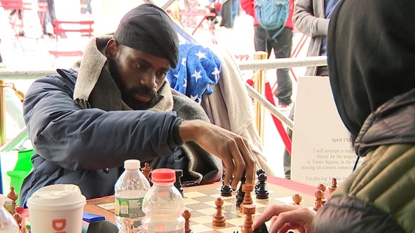 Man trying to break record chess record from folding table in Times Square