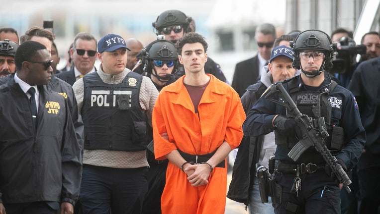 Luigi Mangione, the suspect in the killing of a UnitedHealth Group Inc. chief executive officer Brian Thompson, center, arrives by helicopter from Pennsylvania in New York, US, on Thursday, Dec. 19, 2024. Mangione was extradited to New York to face murder charges after he dropped his opposition to the move in court on Thursday. Photographer: Michael Nagle/Bloomberg via Getty Images