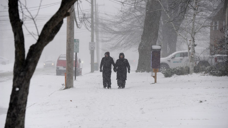 HAMBURG, NEW YORK - NOVEMBER 30: A couple makes their way through lake effect snow to attend the annual Hamburg Holiday Parade on November 30, 2024 in Hamburg, New York. The Northeast storm that closed a 90 mile stretch of The New York State Thruway and snarled holiday traffic across the country dumped more than four feet of snow around Buffalo and its southern suburbs and is expected to continue Throughout the weekend. (Photo by John Normile/Getty Images)