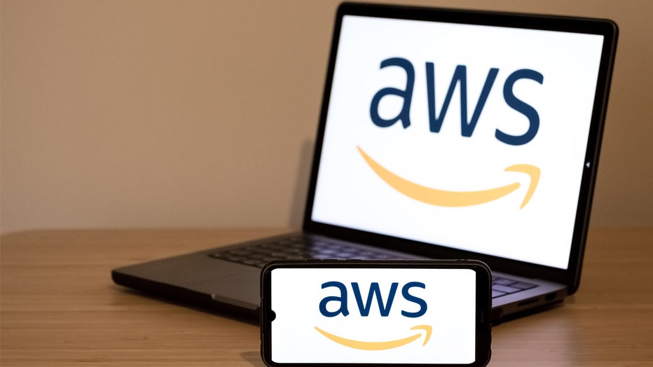 The Amazon Web Services (AWS) logo appears on a smartphone screen and on a laptop computer screen in this photo illustration in Athens, Greece, on October 3, 2025. (Photo Illustration by Nikolas Kokovlis/NurPhoto via Getty Images)

