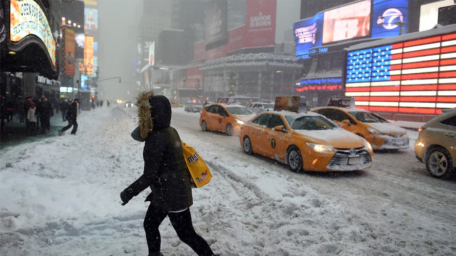 NEW YORK, NY - JANUARY 23: Pedestrians cope with snow covering sidewalks and streets in Time Square on January 23, 2016 in New York City. A major Nor'easter is hitting much of the East Coast and parts of the South as forecasts warn of up to two feet of snow in some areas. (Photo by Astrid Riecken/Getty Images)