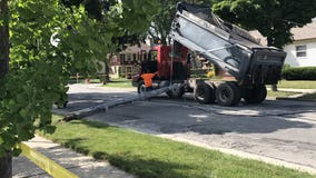 Power knocked out to at least 5 homes after crash involving dump truck, power poles