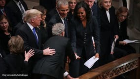 Sweet gesture: George W. Bush hands Michelle Obama a piece of candy at his father's funeral