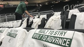 Crews drape t-shirts on seats at Fiserv Forum ahead of game against Celtics