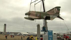 "Emblem of the heroes of America:" Vietnam era fighter hoisted into place at Mitchell Intl. Airport