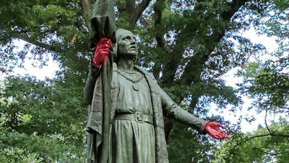 Christopher Columbus statue vandalized with graffiti, hands painted red