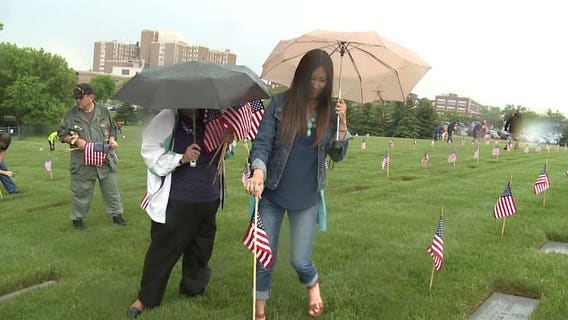 Volunteers prep flags at Wood National Cemetery for Memorial Day ceremony