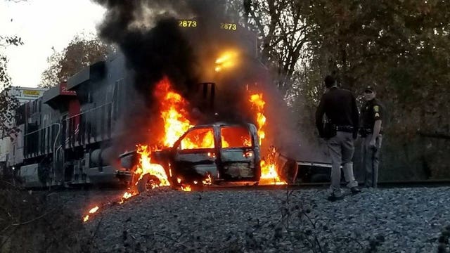 Vehicle struck by train, catches fire after driver "disregarded a closed road" sign