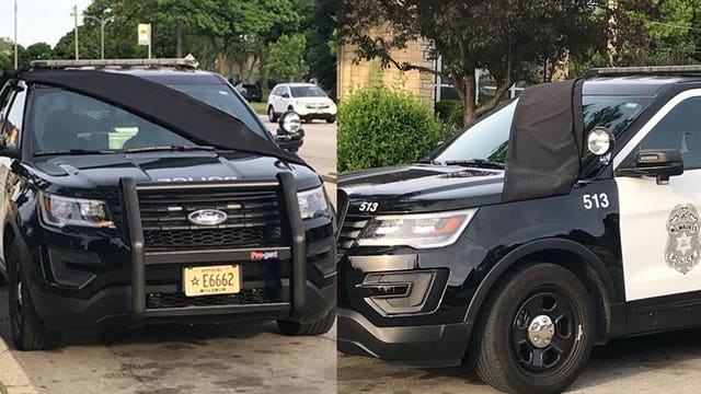 Squad car draped in black, parked outside MPD District 4 in honor of officer killed in crash