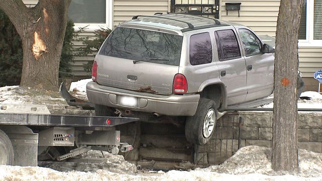 SUV leaves road, jumps sidewalk and ends up on top of landscaping wall