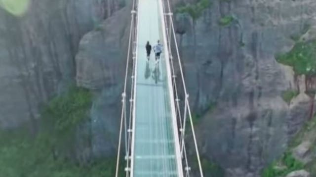 Watch: Tourists take a brave walk across suspended glass-bottomed bridge in China