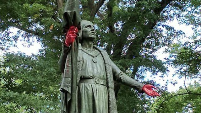 Christopher Columbus statue vandalized with graffiti, hands painted red
