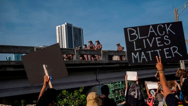 Florida police officer suspended for pushing kneeling woman