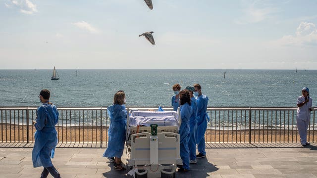 Hospital staff in Spain wheels recovering coronavirus patients to the beach
